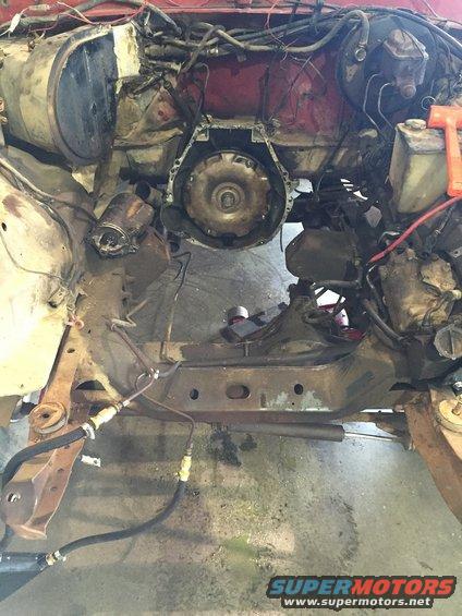 Engine bay with transmission removed, showing frame and brake lines