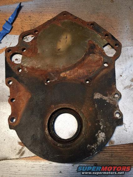 rusted engine timing cover with a circular opening for a seal