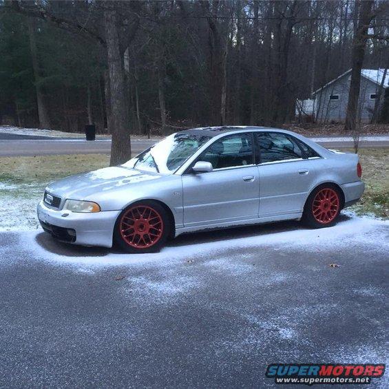 Silver 2001 Audi S4 sedan with red wheels parked on a snowy driveway