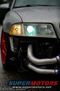 Front view of a silver car with exposed intercooler piping and a red wheel