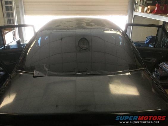 Car interior showing rear window and open doors. Watermark reads SUPERMOTORS.NET