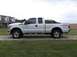 2011 Ford F-250 - This white 2011 Ford F-250 Super Duty pickup truck is seen from the side, parked on a gravel driveway.