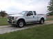 2011 Ford F-250 - White 2011 Ford F-250 pickup truck with chrome accents and FX4 badging is parked on a gravel road.