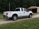 2011 Ford F-250 - A white 2011 Ford F-250 Super Duty pickup truck is parked on a gravel driveway next to a barn.