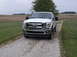 2011 Ford F-250 - Front view of a white 2011 Ford F-250 Super Duty pickup truck on a gravel drive.