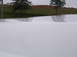 2011 Ford F-250 - The top of a white truck hood is visible, reflecting the overcast sky and surrounding landscape.