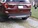 2016 Ford Explorer - The rear of a maroon Ford Explorer shows its taillights, chrome trim, and dual exhaust pipes.