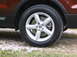 2016 Ford Explorer - A close-up view of a vehicle's wheel and fender flare, with the tire resting on gravel and grass.