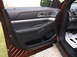 2016 Ford Explorer - Interior view of the driver's side door panel and floor mat in a maroon SUV.