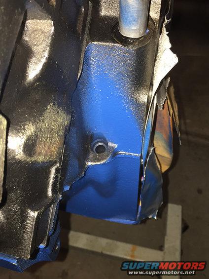 Close-up of engine block with blue paint and peeling tape