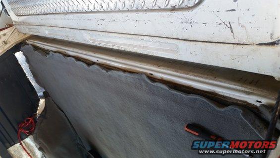 Removing carpet and trim from inside a vehicle, showing the metal body and weatherstripping channel