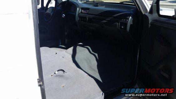 1992 Ford Bronco interior, gray carpet, dark dashboard, steering wheel, open door
