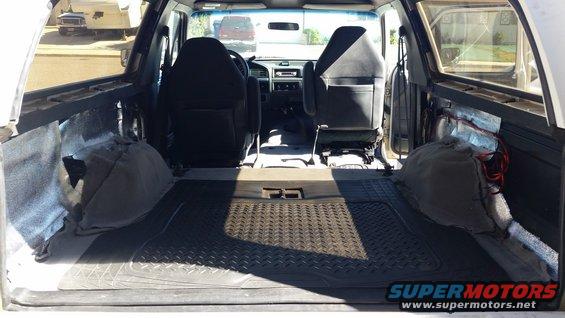 Interior of a 1992 Ford Bronco, showing front seats, rear cargo area with rubber mat, and door panels