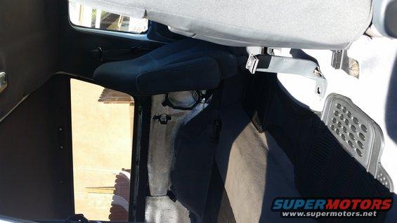 Interior view of a vehicle with dark blue seats and gray carpet
