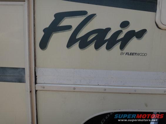 RV side panel showing 'Flair' decal by Fleetwood. Supermotors.net logo visible