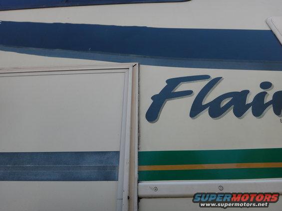 RV side panel showing 'Flair' graphic and blue/green stripes. Also has a 'Supermotors' watermark