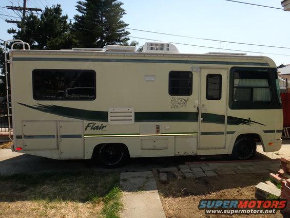 Motorhome with side graphics and multiple windows parked outdoors