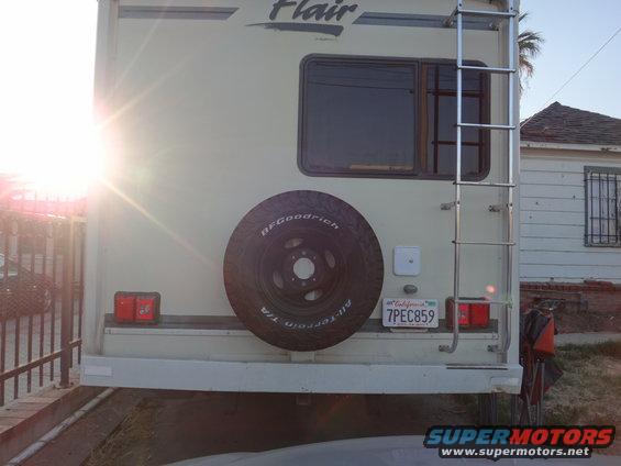 RV rear with spare tire, ladder, and California license plate 7PEC859