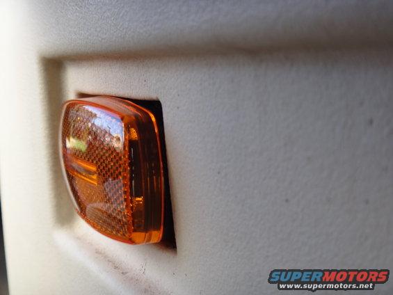Close-up of an orange marker light on a vehicle's interior panel