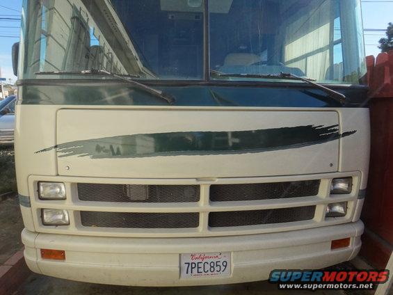 Front view of a white step van with a green stripe and California license plate 7PEC859