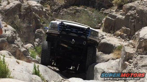 White Ford F-Series truck navigating a rocky off-road trail