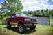 1995 Ford Bronco - This lifted 1995 Ford Bronco is parked in a rural setting with a shed in the background.