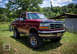 1995 Ford Bronco - This lifted Ford Bronco is ready for adventure, parked outdoors on a sunny day.