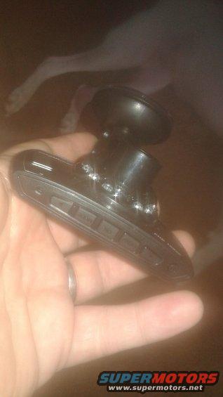 Hand holding a black dash cam with suction cup mount