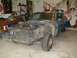 1967 Ford Mustang - This blue 1967 Ford Mustang coupe is in a garage, appearing to be undergoing restoration with its front end disassembled.