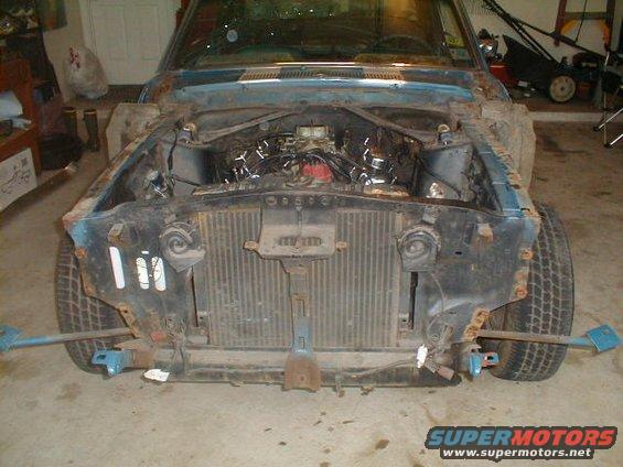 1967 Ford Mustang front end, blue, rusty, engine exposed, radiator visible, tires on