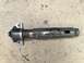1965 Ford Mustang - A metal driveshaft component with a U-joint and mounting brackets is shown against a concrete background.