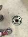 1965 Ford Mustang - A wheel hub assembly sits on a concrete floor next to a pair of athletic shoes.