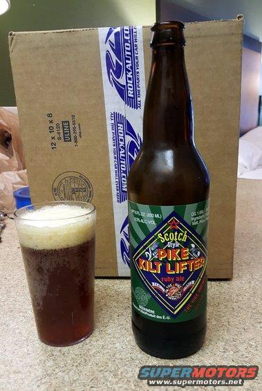 Beer bottle and glass on a counter with a cardboard box behind
