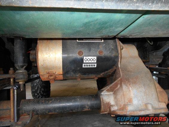 Vehicle underbody showing a motor and differential assembly, with visible rust and a Supermotors.net watermark
