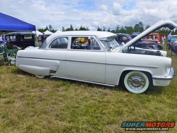 White 1954 Mercury Monterey sedan, hood open, parked on grass