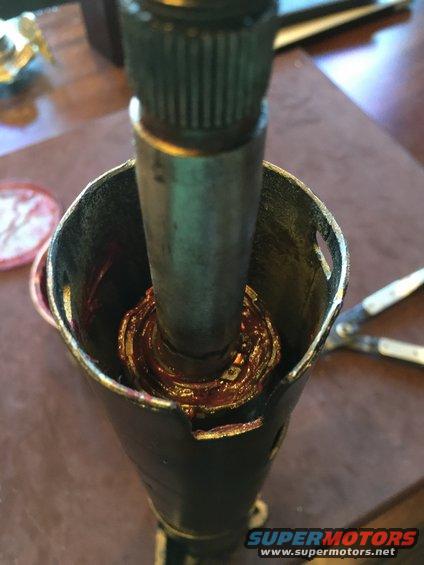 Close-up of a greased steering column component with splines visible at the top