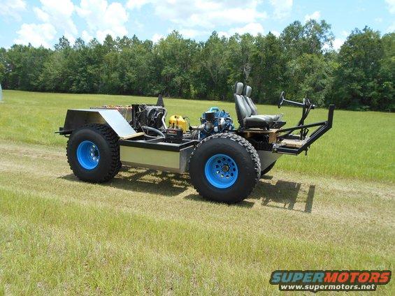 custom off-road vehicle with blue wheels, exposed engine, and two seats
