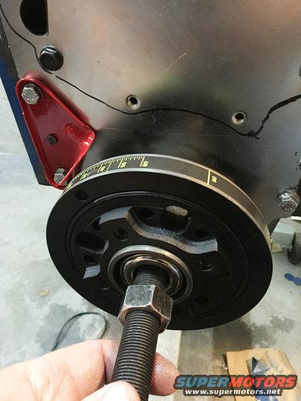 Crankshaft pulley with timing marks and a bolt being threaded in