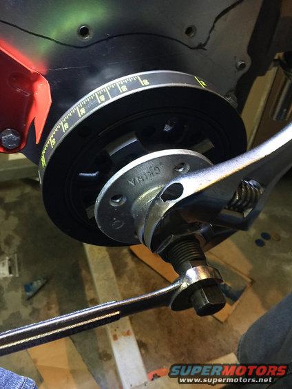 Crankshaft pulley with timing marks and a wrench on the bolt