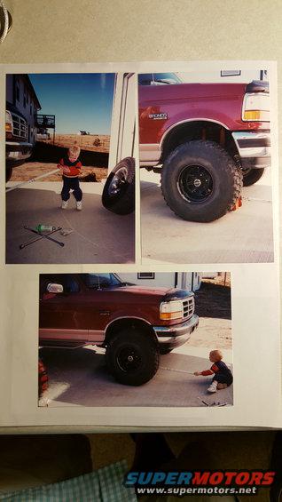 Red 1996 Ford Bronco with large tires, child playing nearby