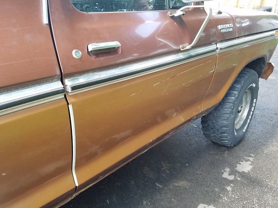 Side view of a brown 1979 Ford Bronco with chrome trim and BFGoodrich tires