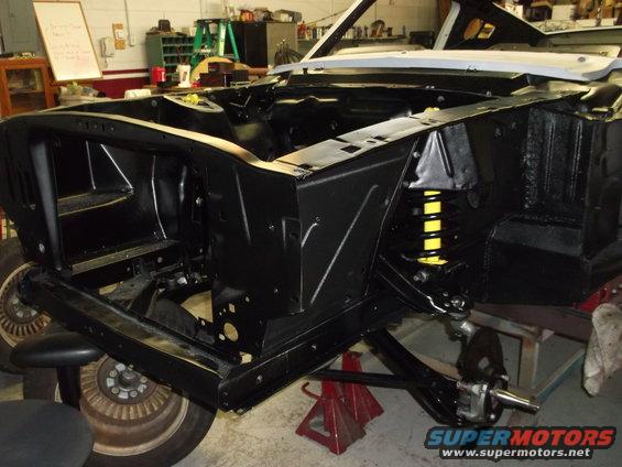 1967 Ford Mustang chassis, front view, undergoing restoration, black paint, yellow springs visible