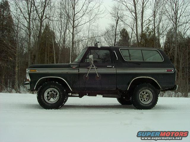 Black 1978 Ford Bronco in snow, side view, with chrome trim and aftermarket wheels
