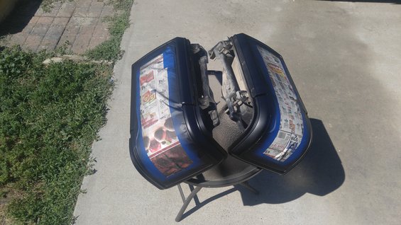 Pair of blue-trimmed tail lights covered in newspaper