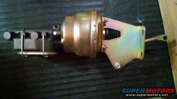 Brake booster and master cylinder assembly with gold and black finish, mounted on a dark surface