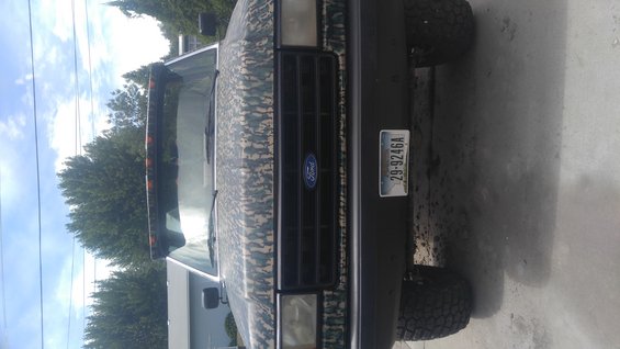 1991 Ford Bronco with camouflage wrap, front view, showing a license plate