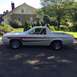 1972 Ford Ranchero - A white 1977 Ford Ranchero with red side stripes is parked in front of a house on a sunny day.