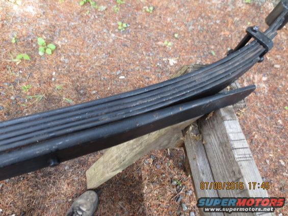 Leaf springs on wooden supports, with a shoe visible at the bottom left