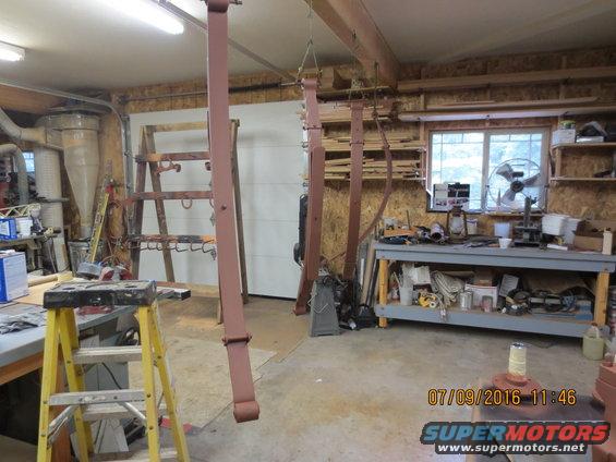Workshop with leaf springs hanging and tools on a workbench