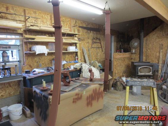 Workshop with car lift, wood stove, and tools. Date stamp shows 07/09/2016